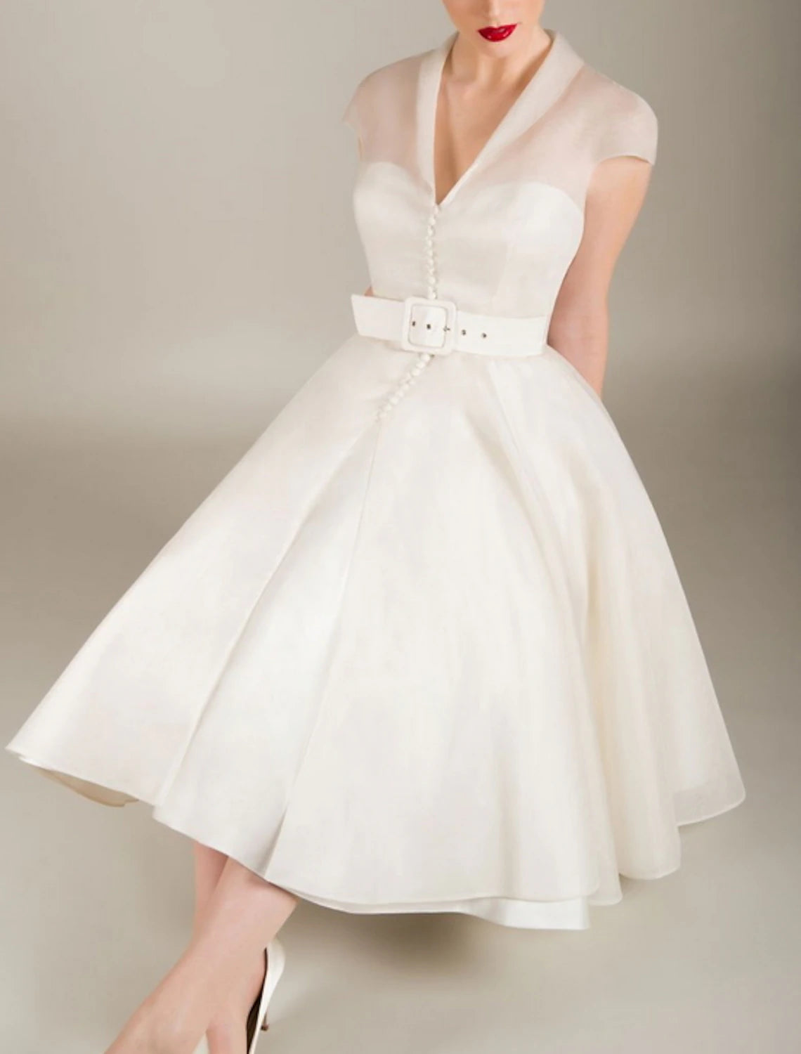 Detail of the V-neckline and sleeveless design of the cocktail dress.
