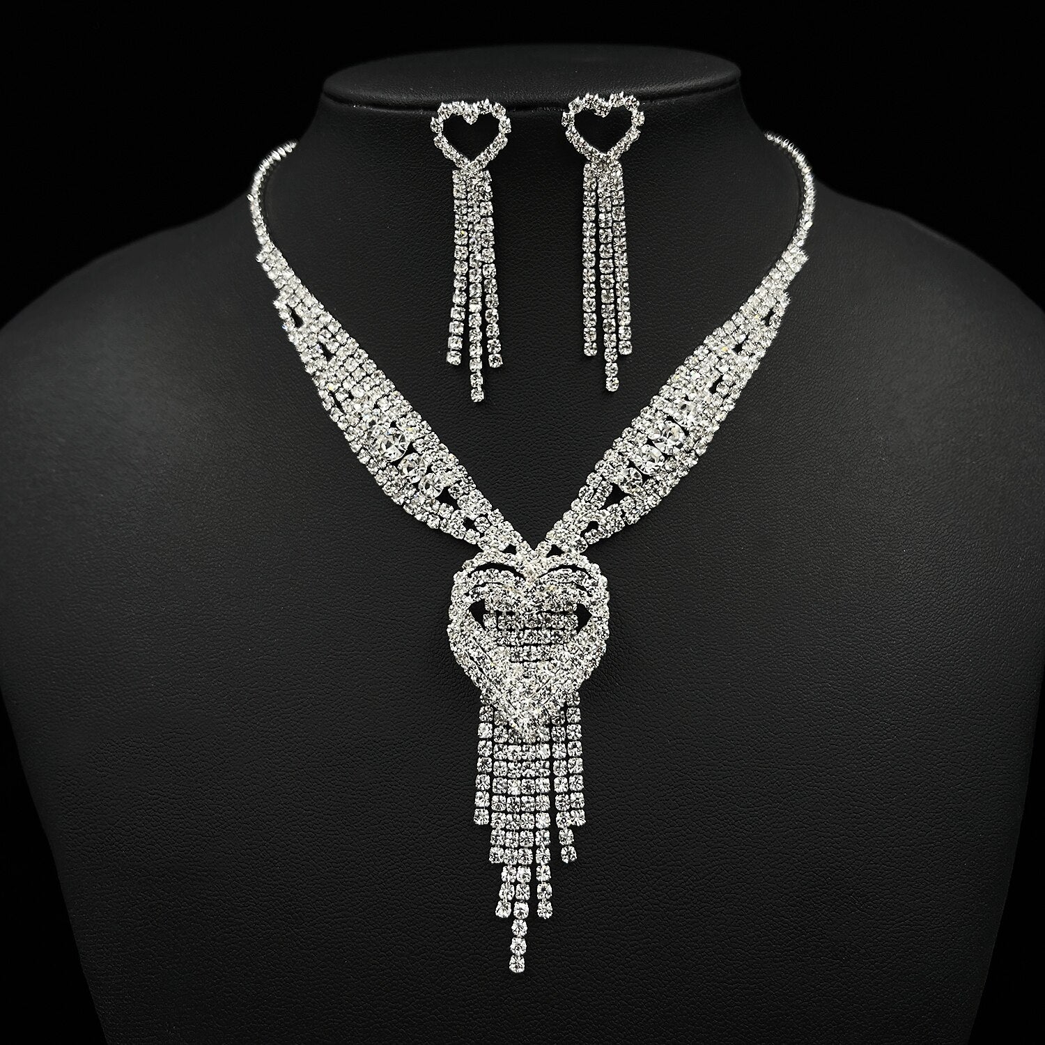 Woman wearing a heart tassel necklace and matching earrings for a wedding.