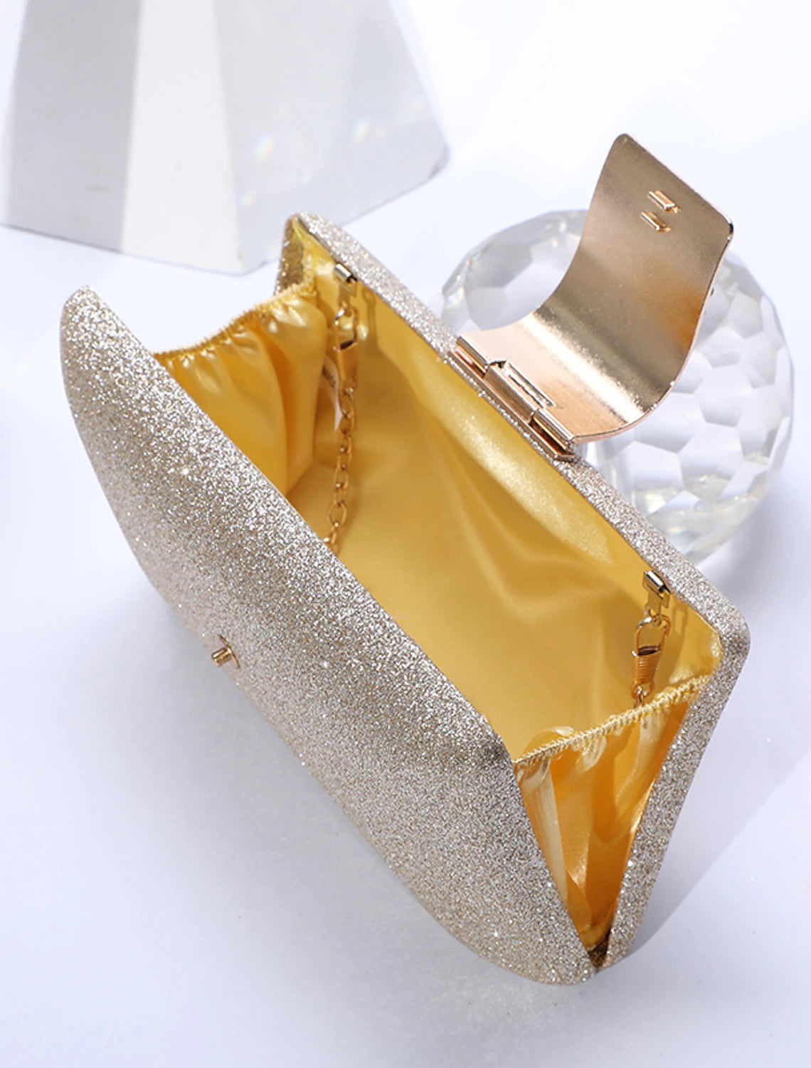 Close-up of sparkling crystals on a solid color clutch bag.
