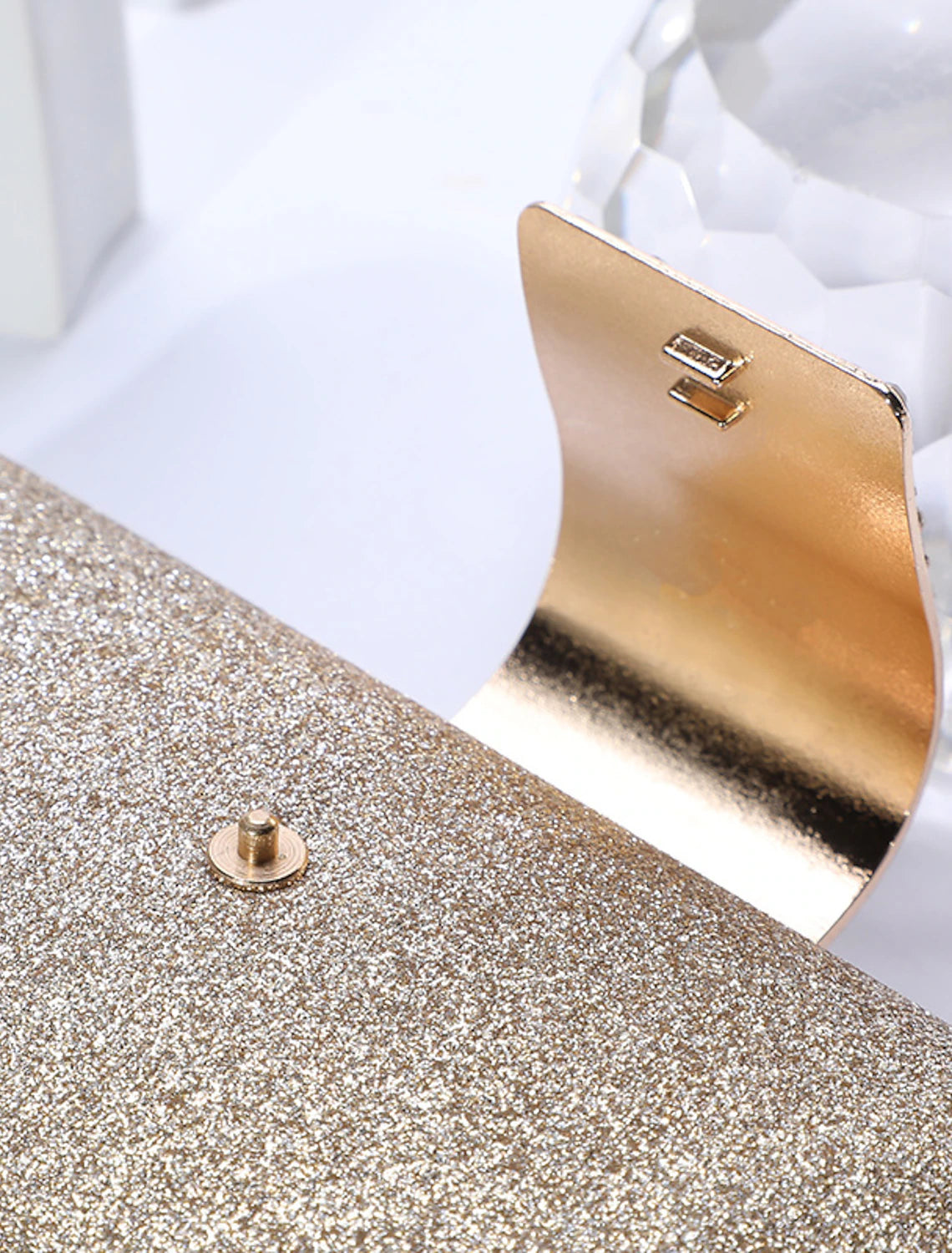 Solid color crystal clutch bag displayed from an angle.