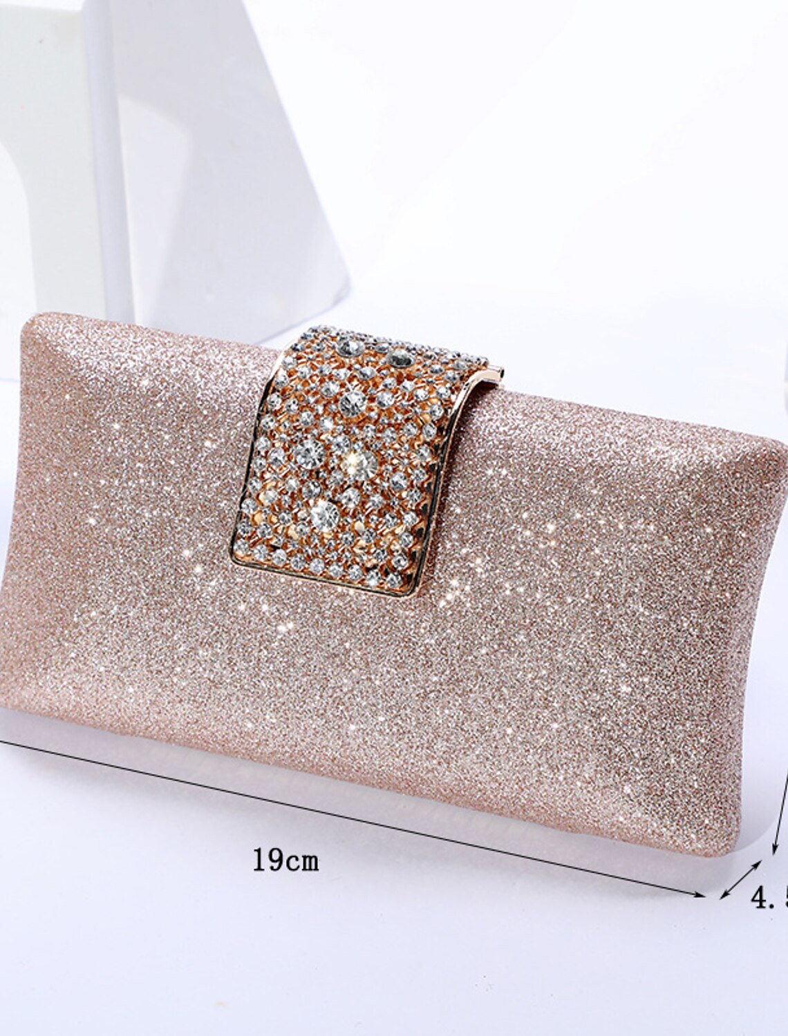 Solid color crystal clutch bag with a chain on a flat surface.