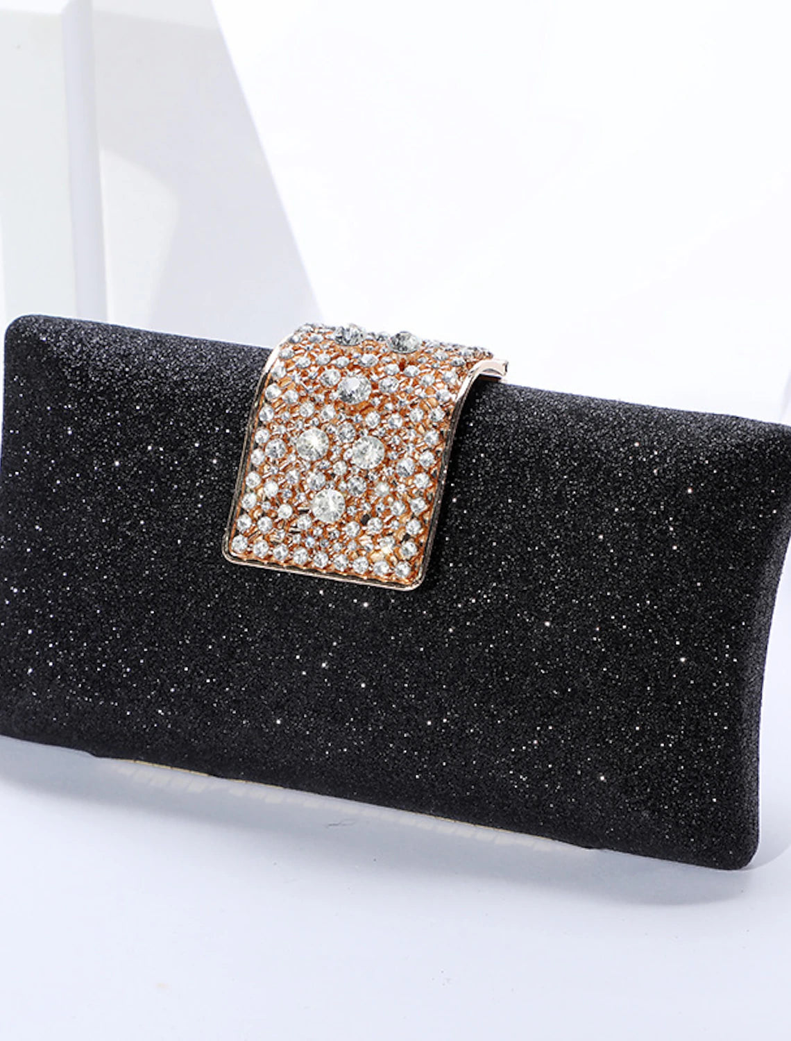Detail of the delicate chain on a solid color crystal clutch bag.