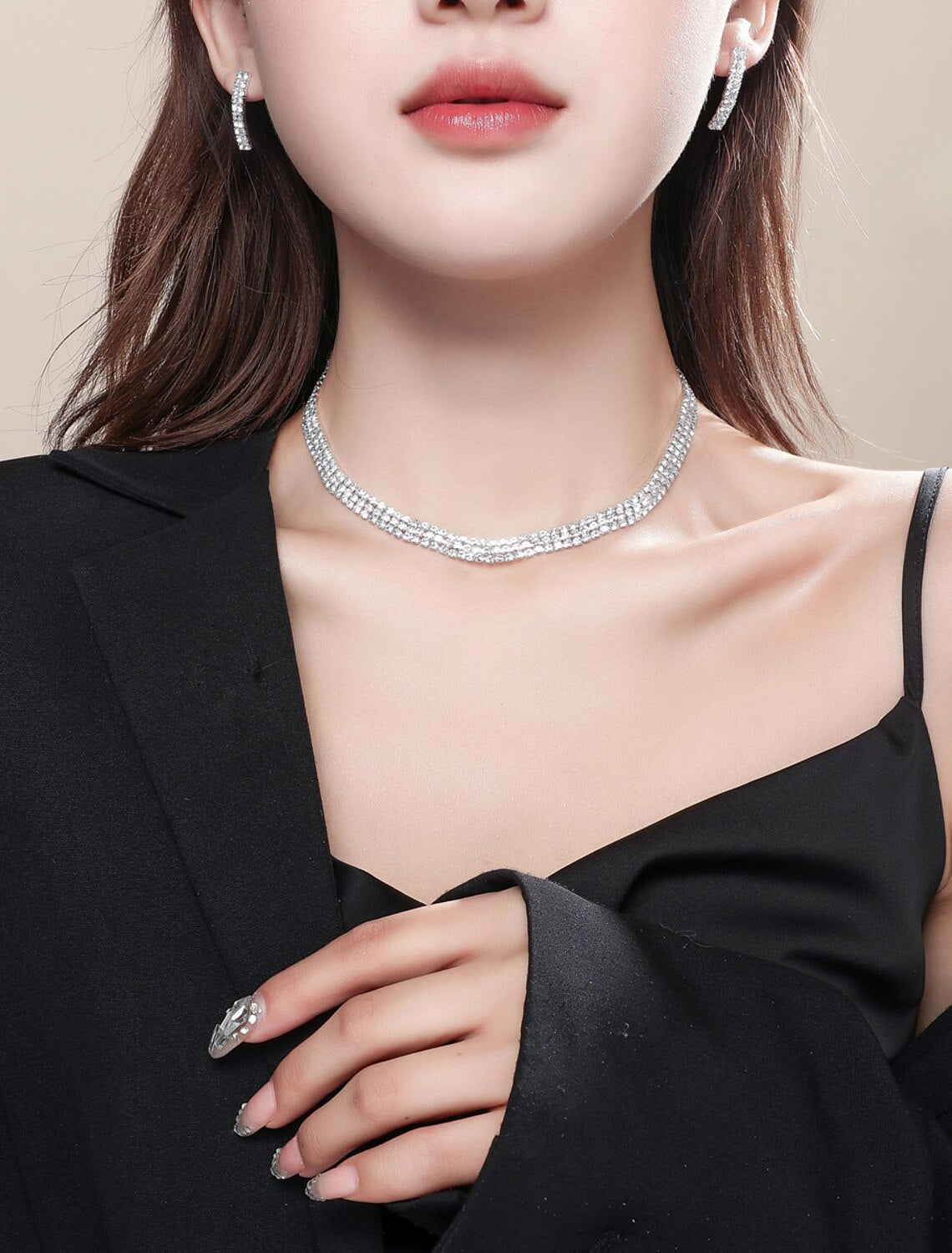 Woman wearing an elegant imitation diamond necklace and matching earrings.