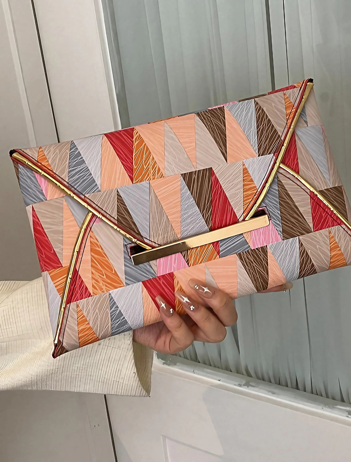 Front view of a women's geometric PU leather evening clutch bag with a buckle closure.