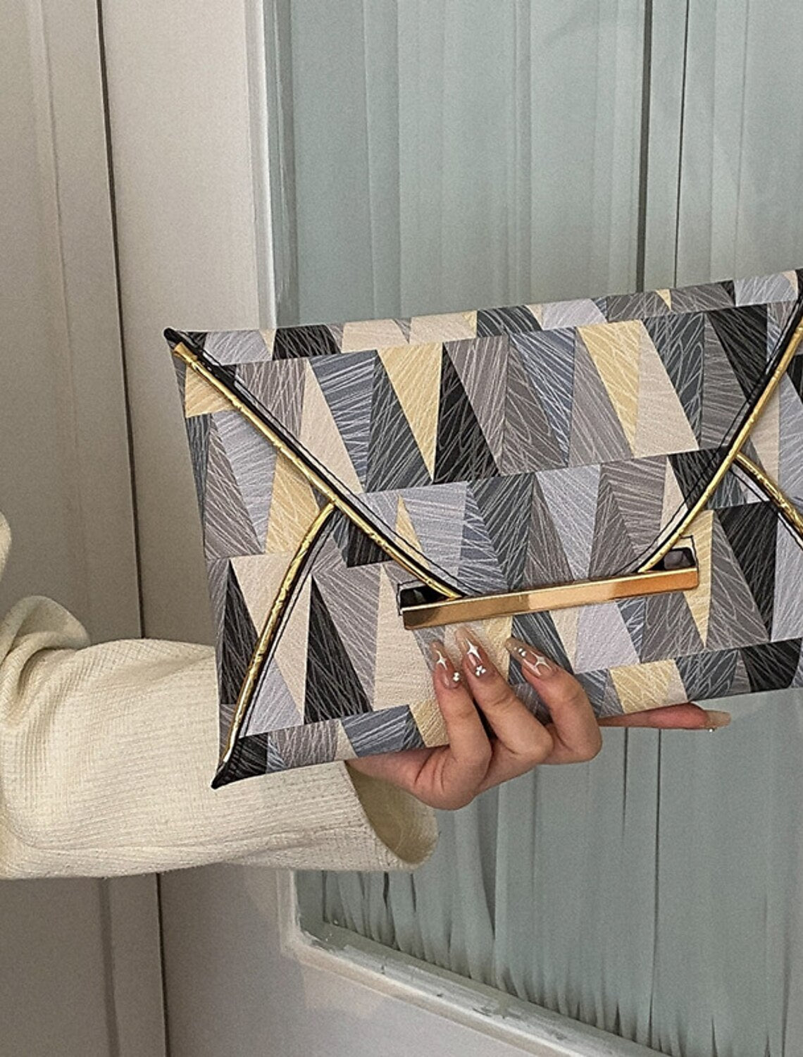 Side profile of the women's geometric PU leather clutch bag.