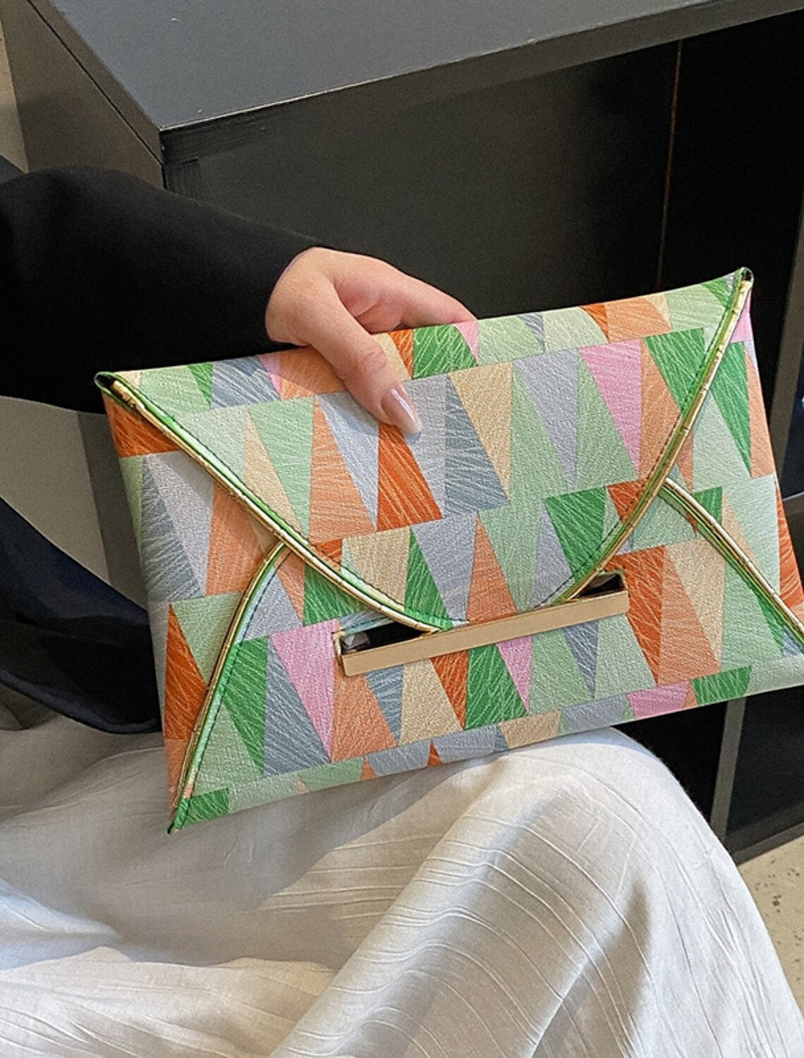 Close-up of the buckle closure on the geometric evening bag.