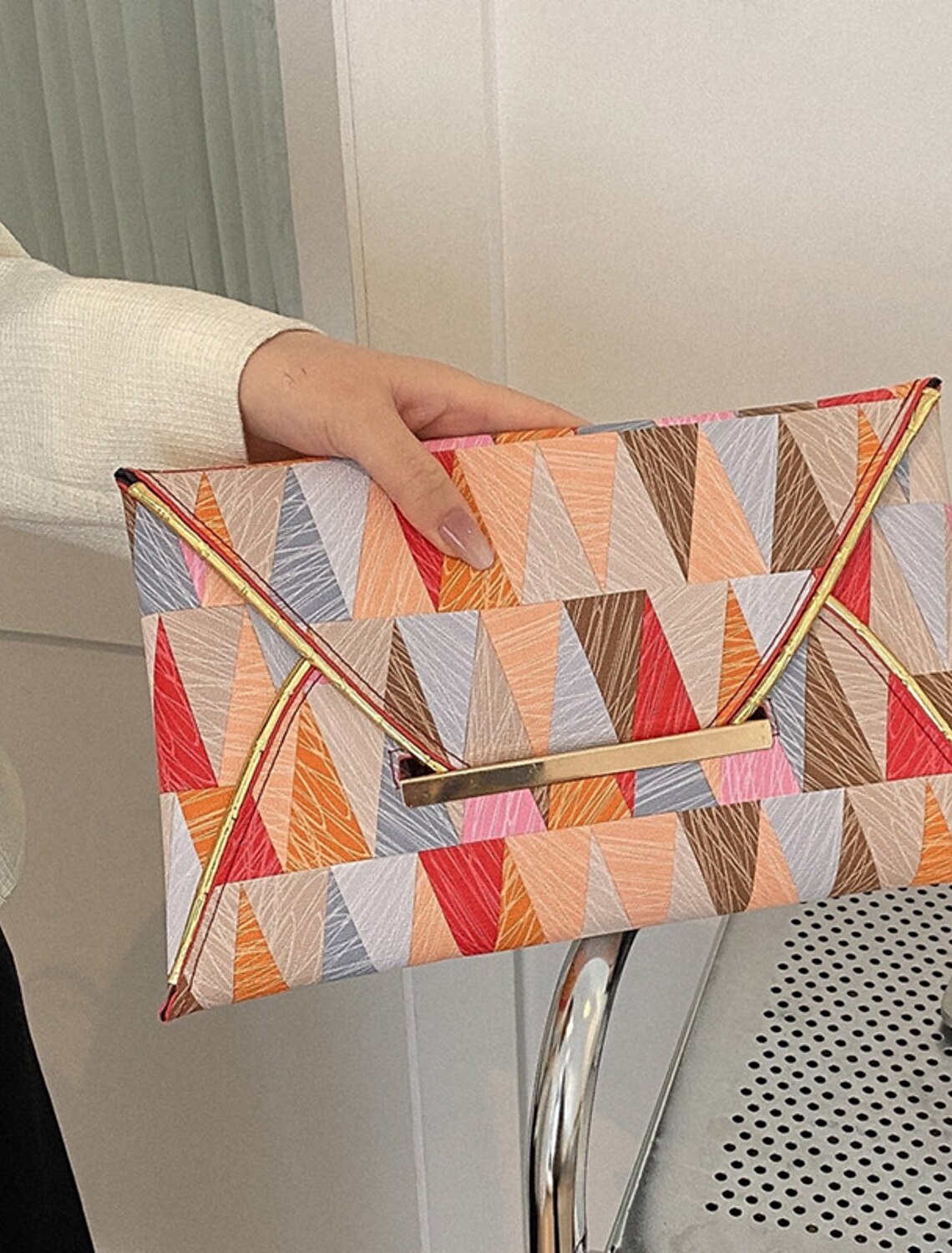 Geometric PU leather clutch bag displayed on a flat surface.