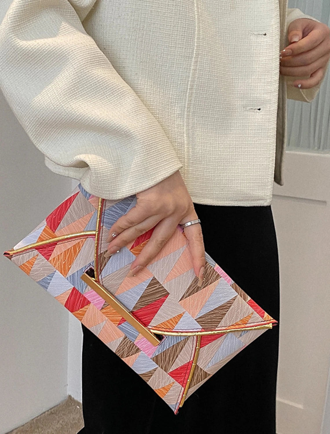 Detail of the waterproof PU leather texture on the geometric clutch bag.