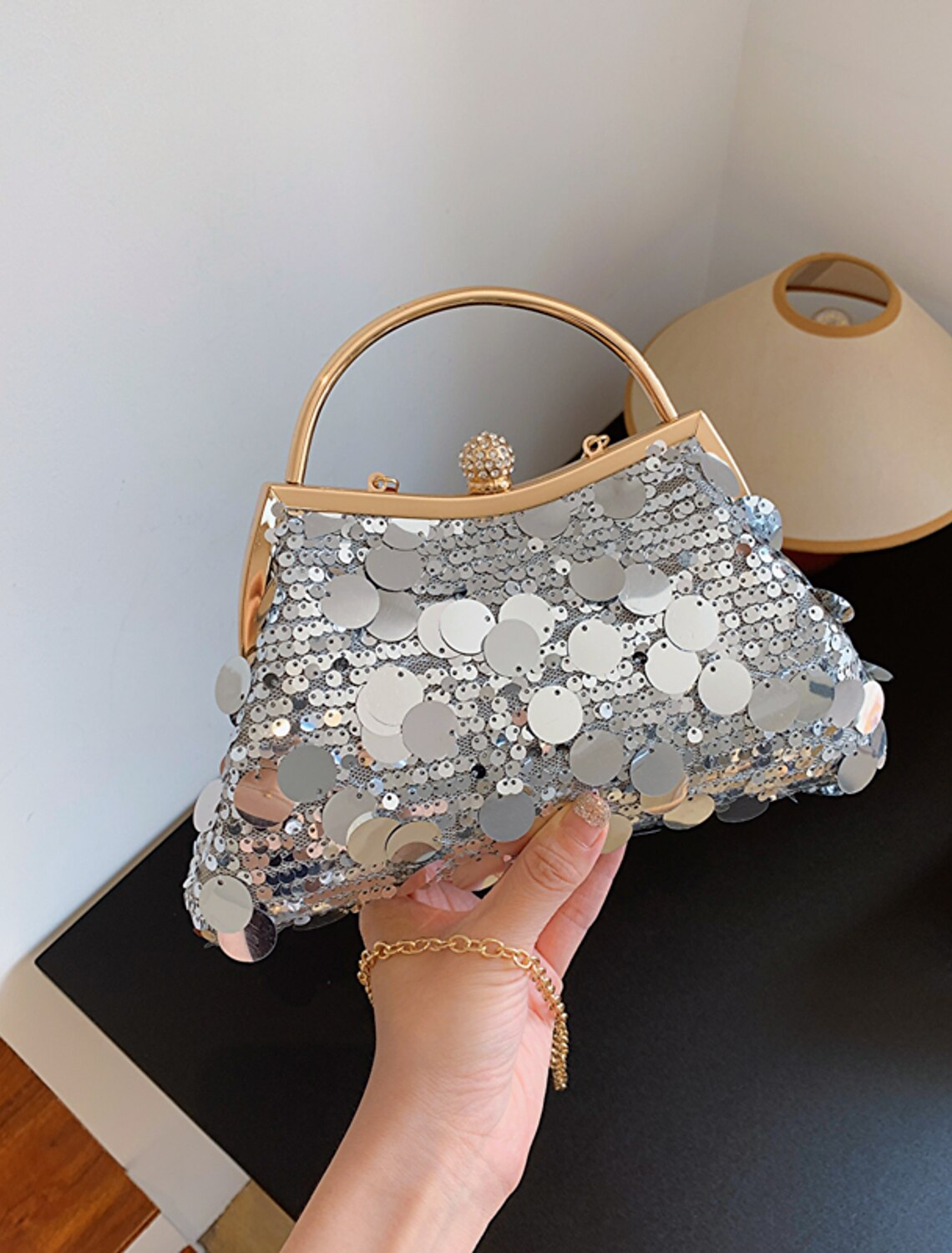 Women holding a geometric sequin evening clutch.