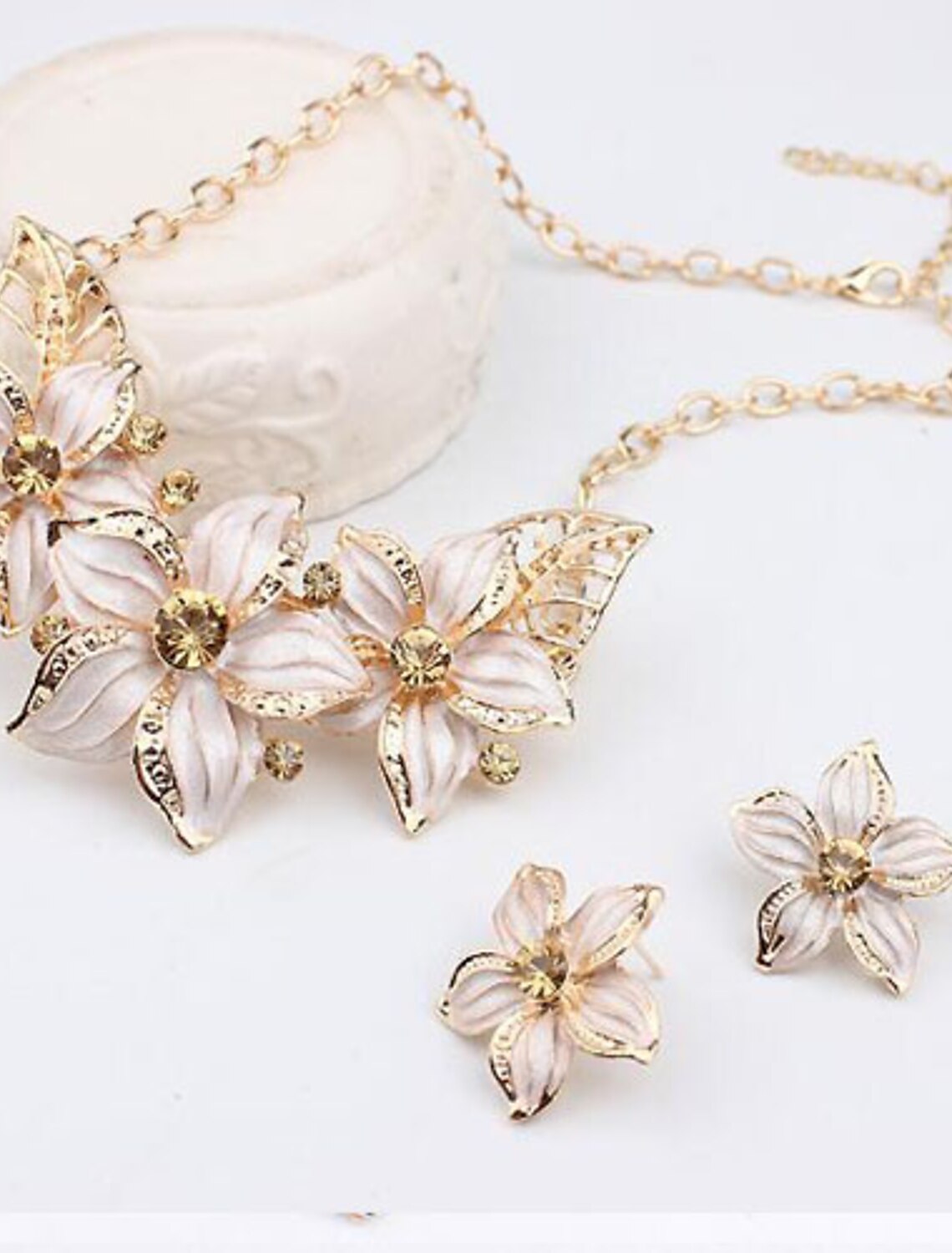 Elegant gold alloy flower necklace and earrings set with synthetic diamonds.