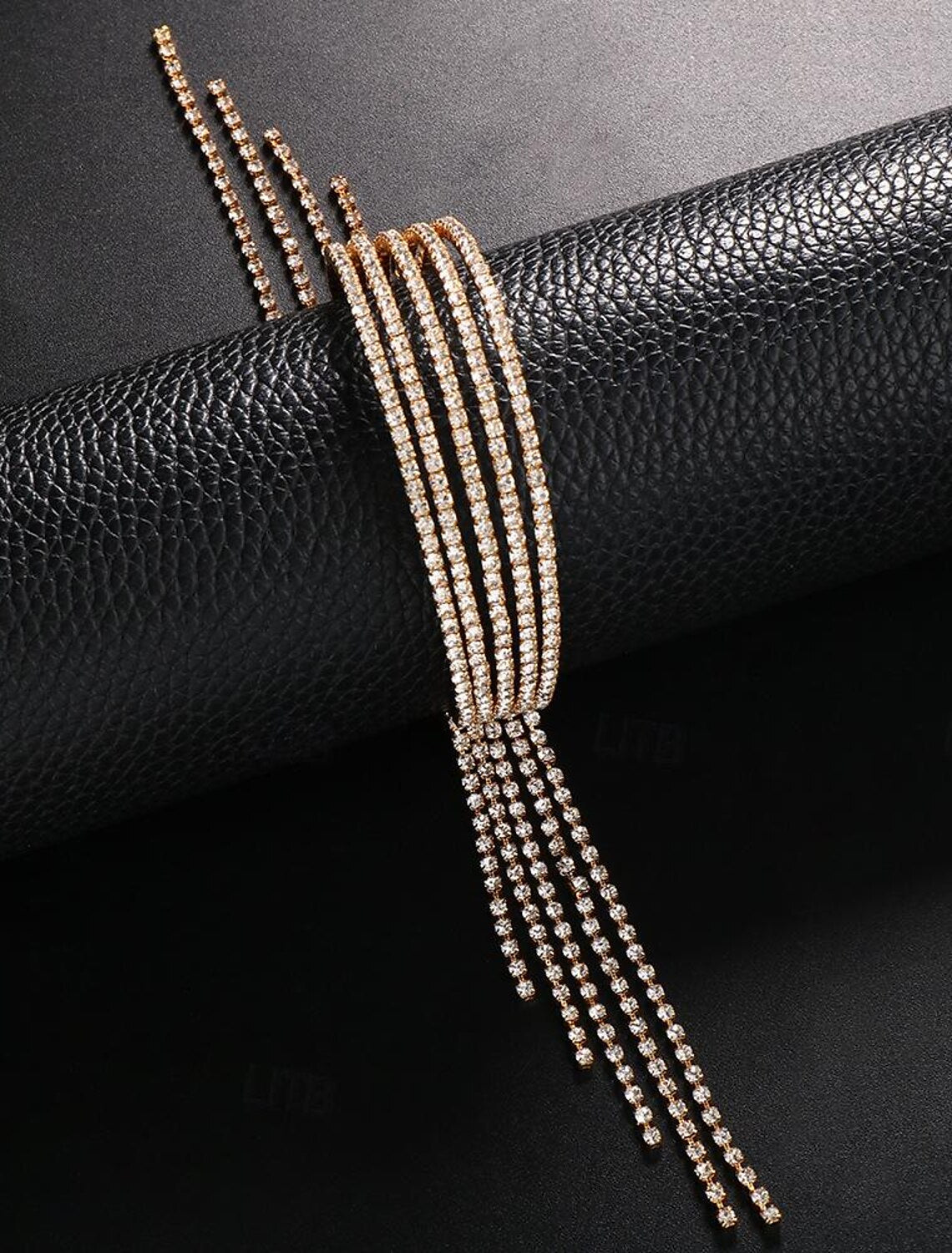 Close-up of the gold rhinestone tennis bracelet with delicate tassel fringe.
