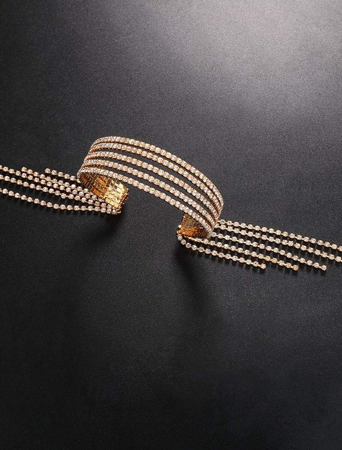 Elegant gold-tone tennis bracelet with sparkling rhinestones and tassel detail.