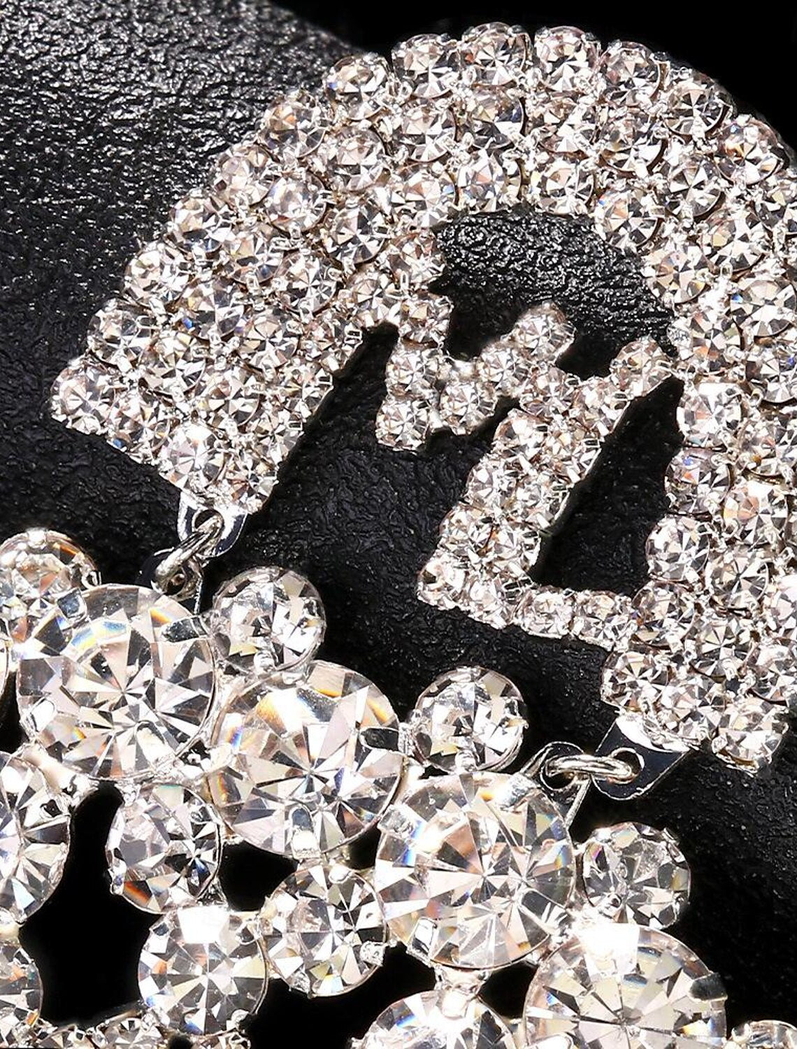 Close-up of a sparkling imitation diamond hoop earring in silver tone.