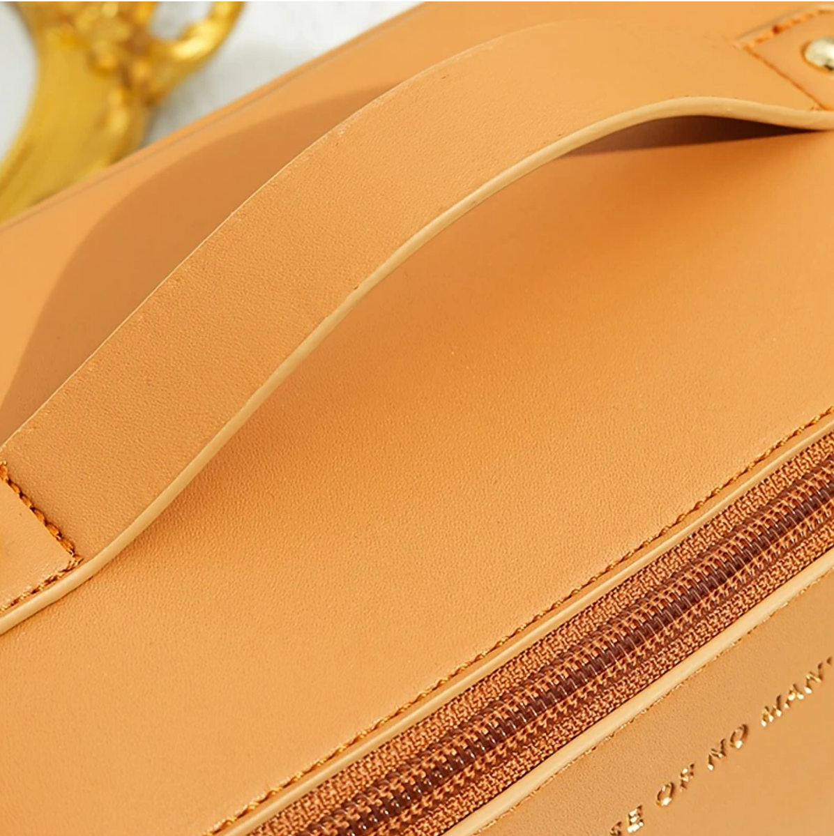 A women's travel wash bag, open, with toiletries neatly arranged inside.