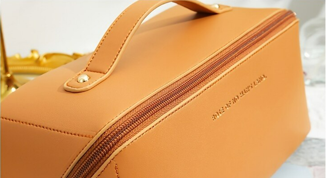 A women's portable cosmetic bag, closed, shown from a top-down perspective.