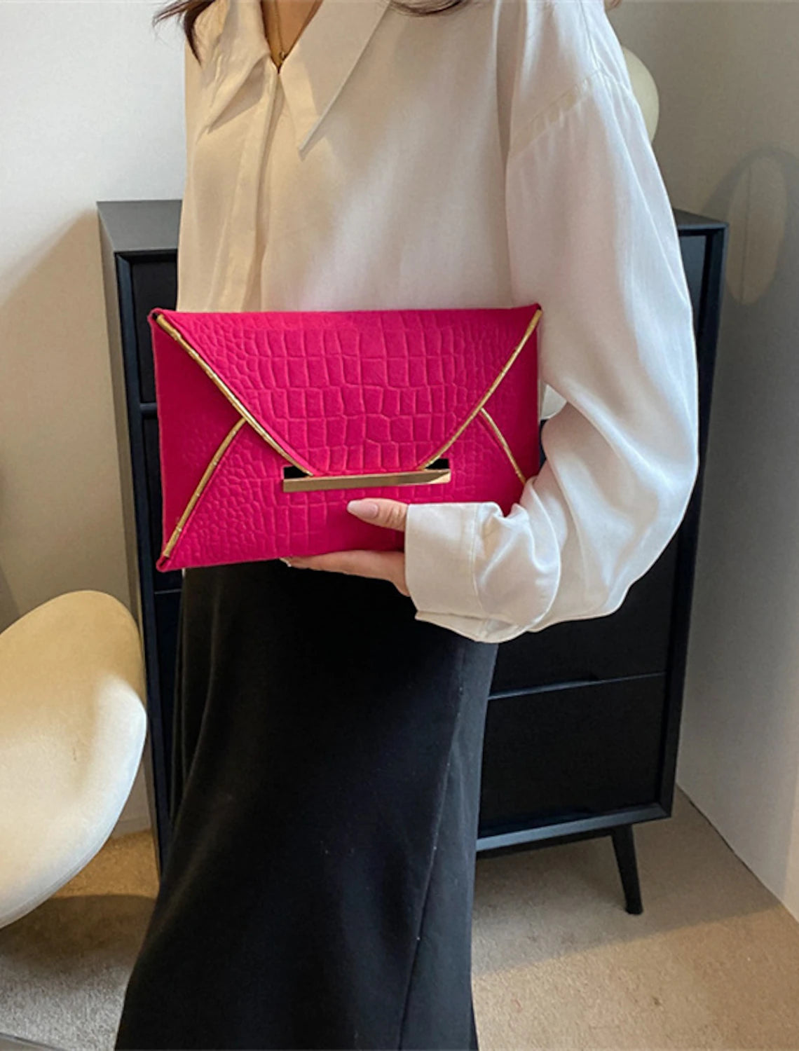 Elegant women's PU leather clutch bag held by hand.