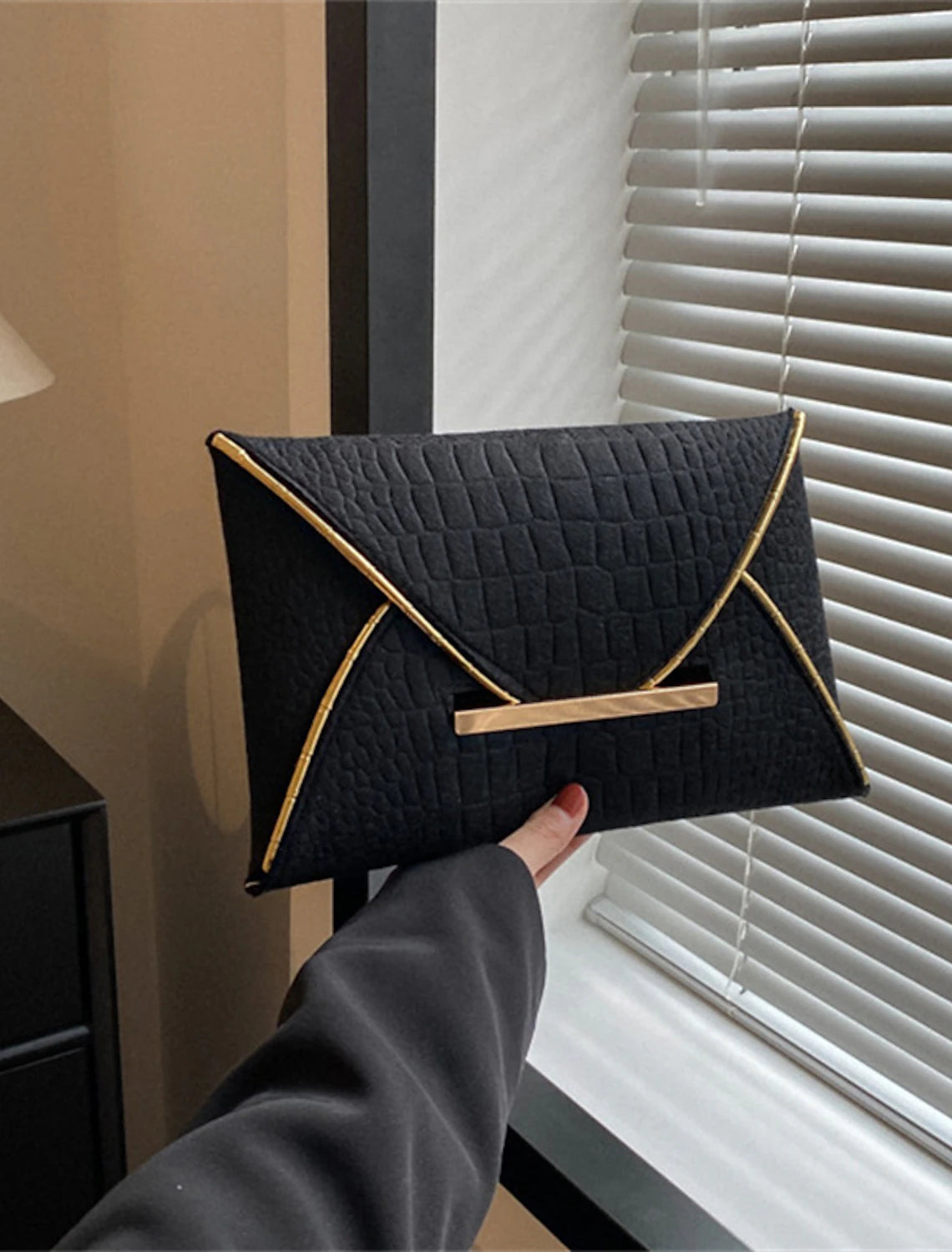 Back view of a women's solid color clutch bag.