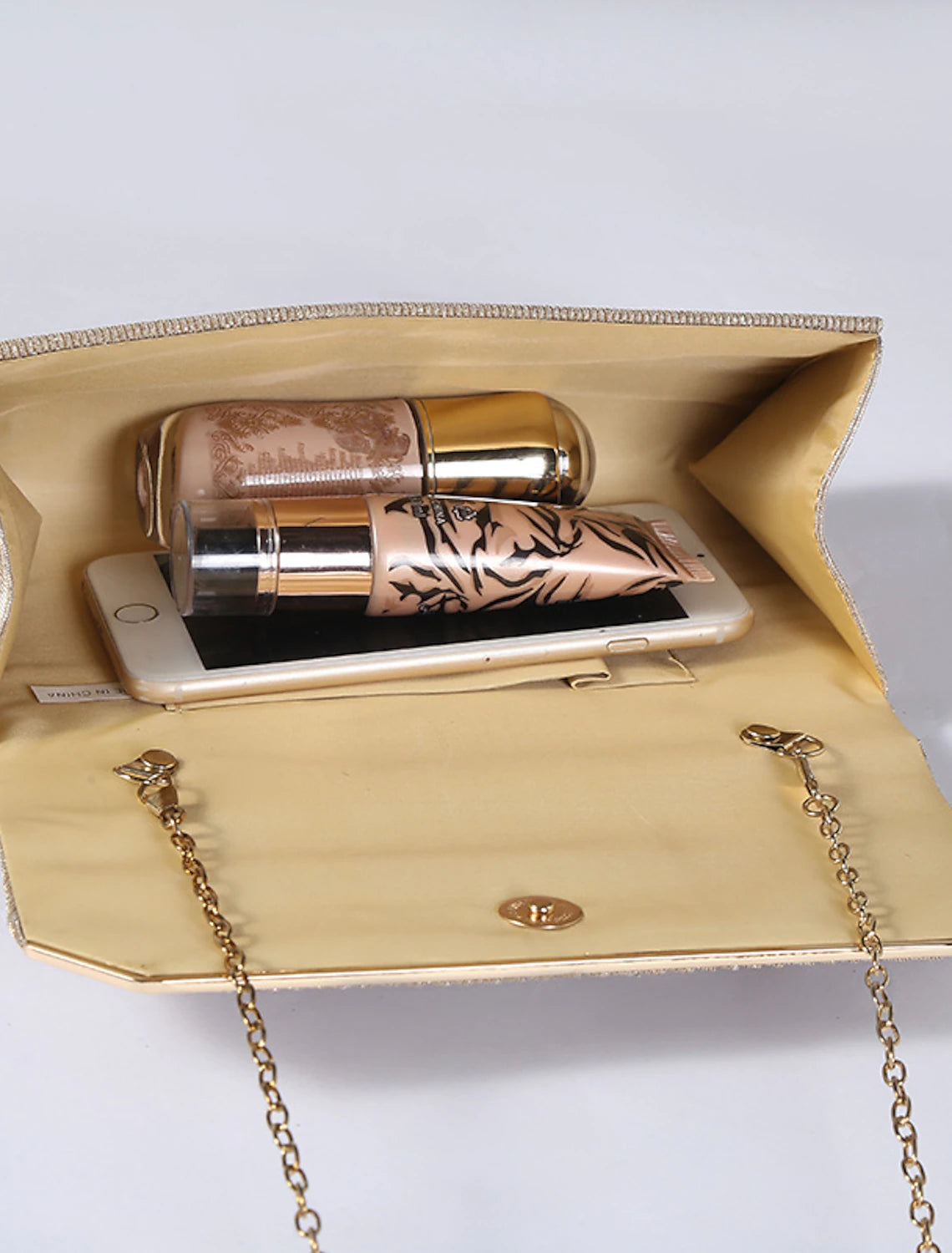 Black PU leather clutch bag held by hand as a wristlet.