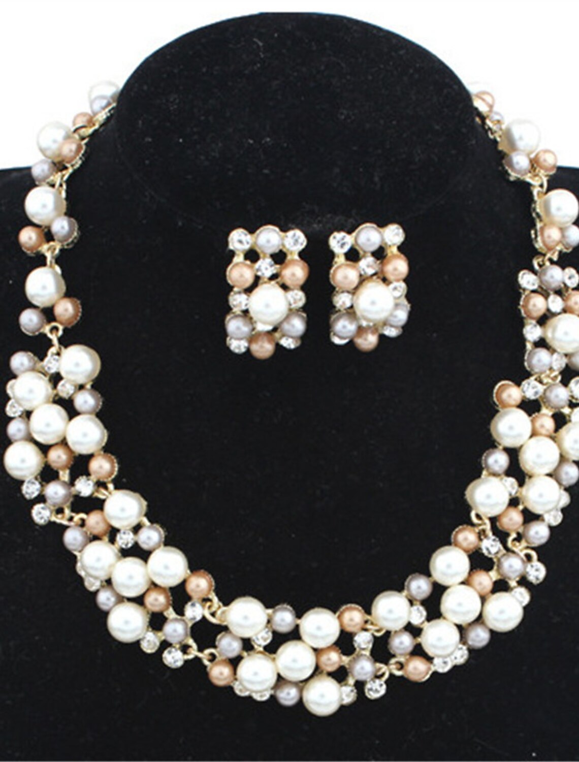 Woman wearing a pearl and rhinestone jewelry set with twisted gold-tone earrings and necklace.