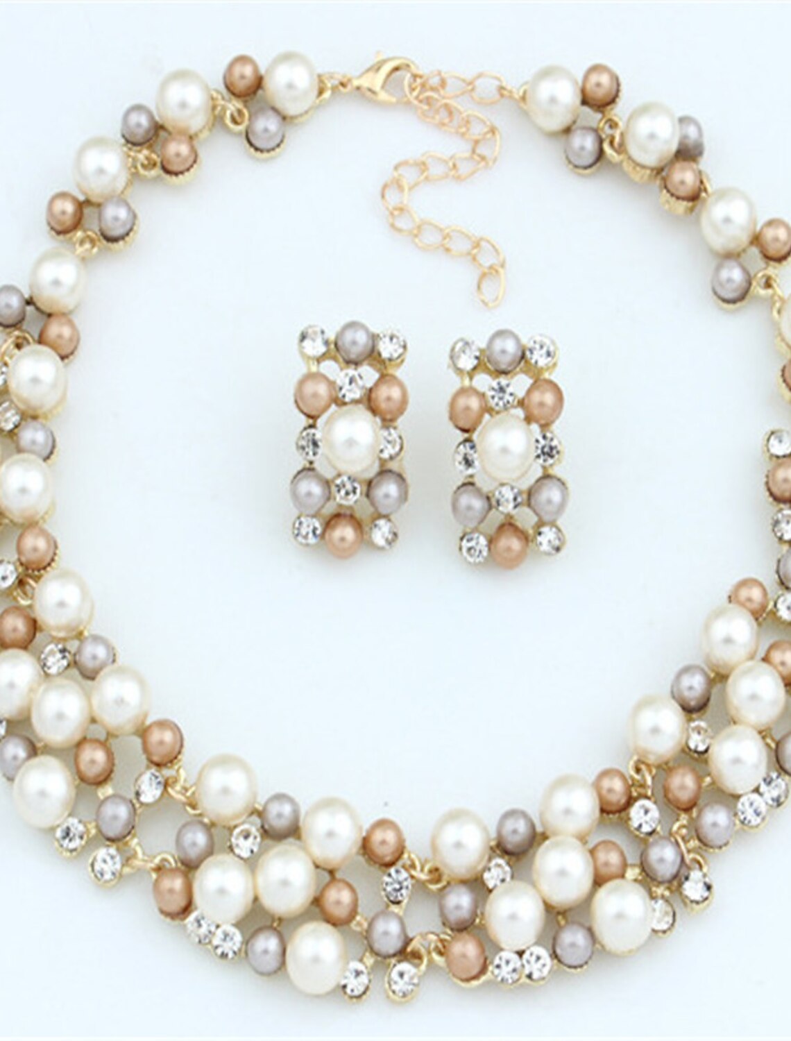 Close-up of a pearl necklace with twisted gold-tone details.