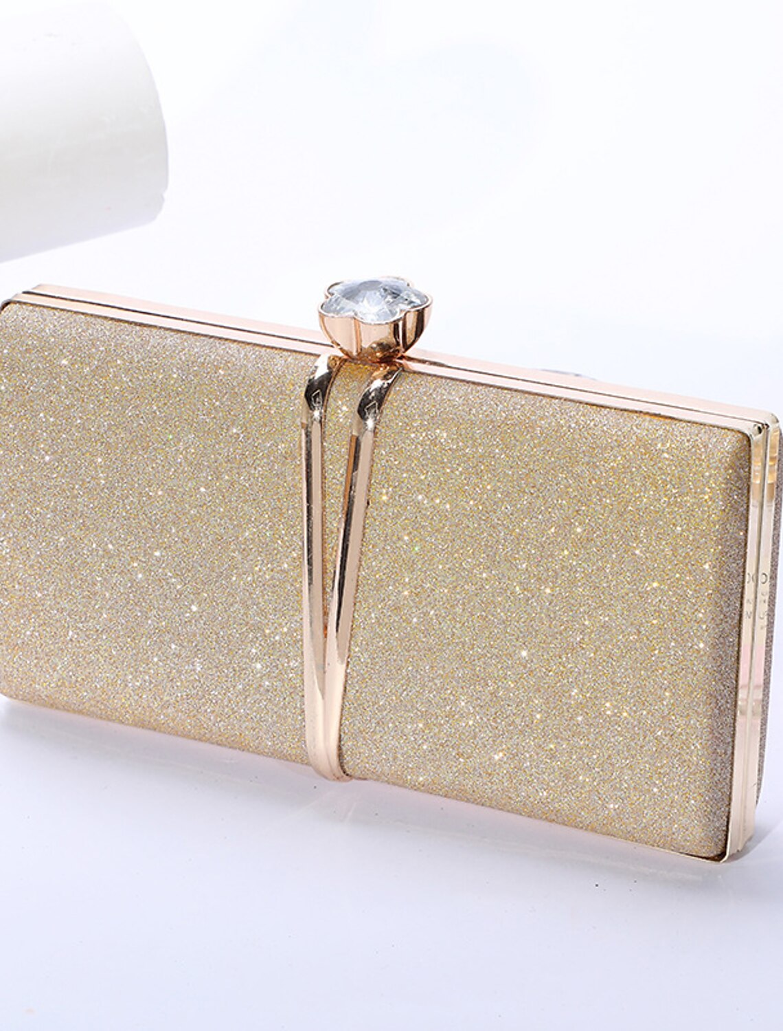 Woman holding a stylish rhinestone evening clutch bag.