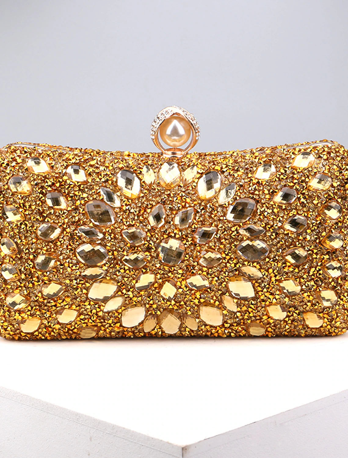Women's rhinestone and pearl evening clutch bag with a chain strap.