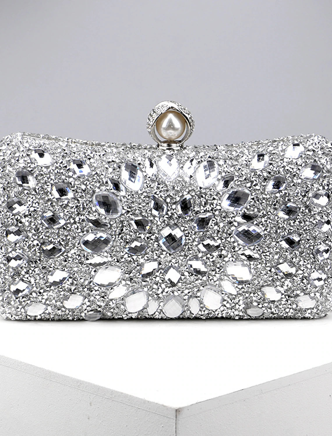 Women's rhinestone and pearl evening clutch bag with a chain strap.