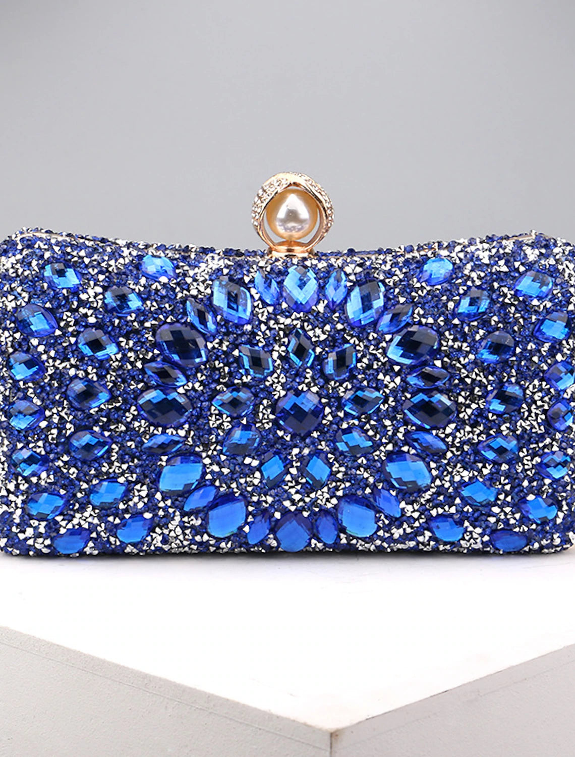 Women's rhinestone and pearl evening clutch bag with a chain strap.