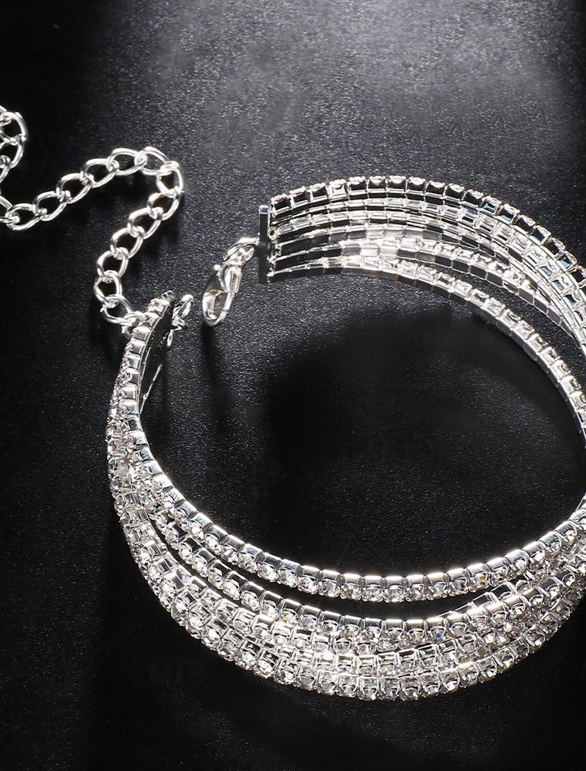 The elegant silver rhinestone tennis bracelet displayed flat, showcasing its intricate design.