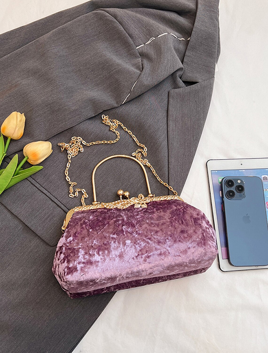 Women's dark velvet dome evening bag with chain strap.