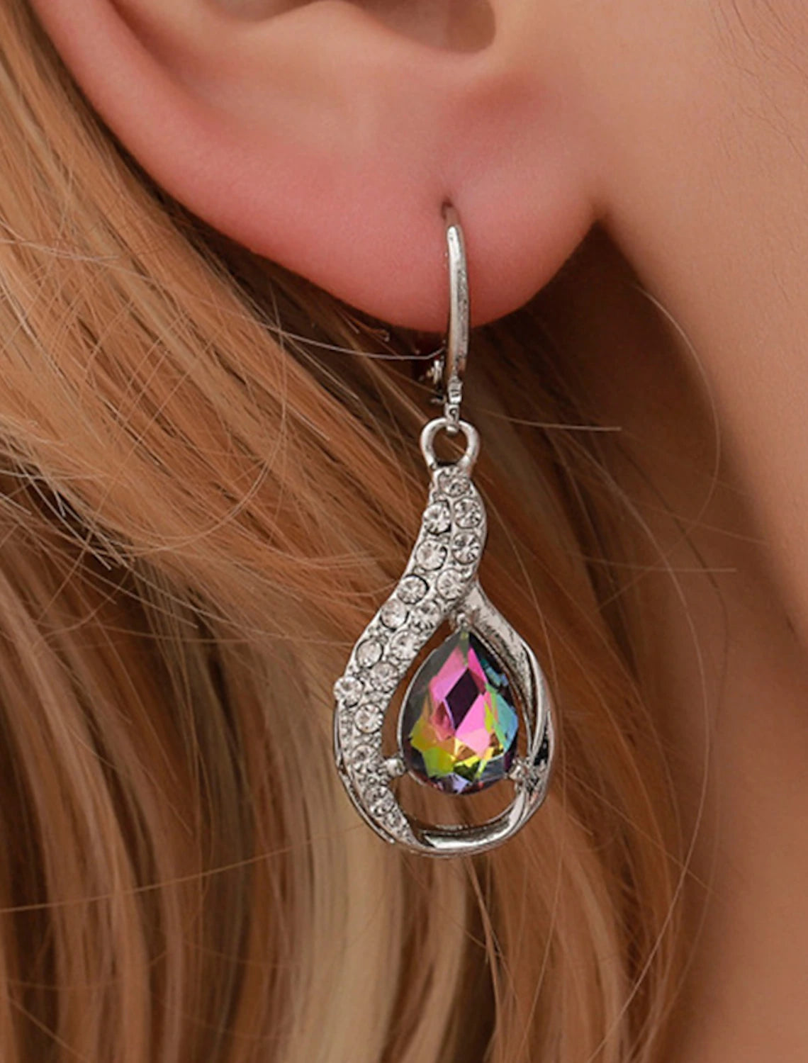 Woman wearing gold-tone zircon drop earrings.