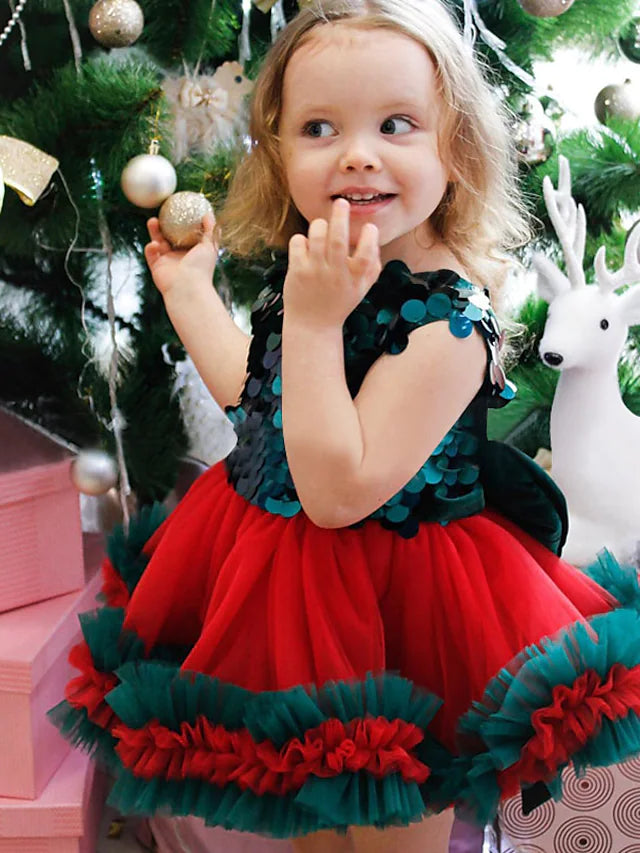 Front view of a charming knee-length tulle flower girl dress with a jewel neck and bows.