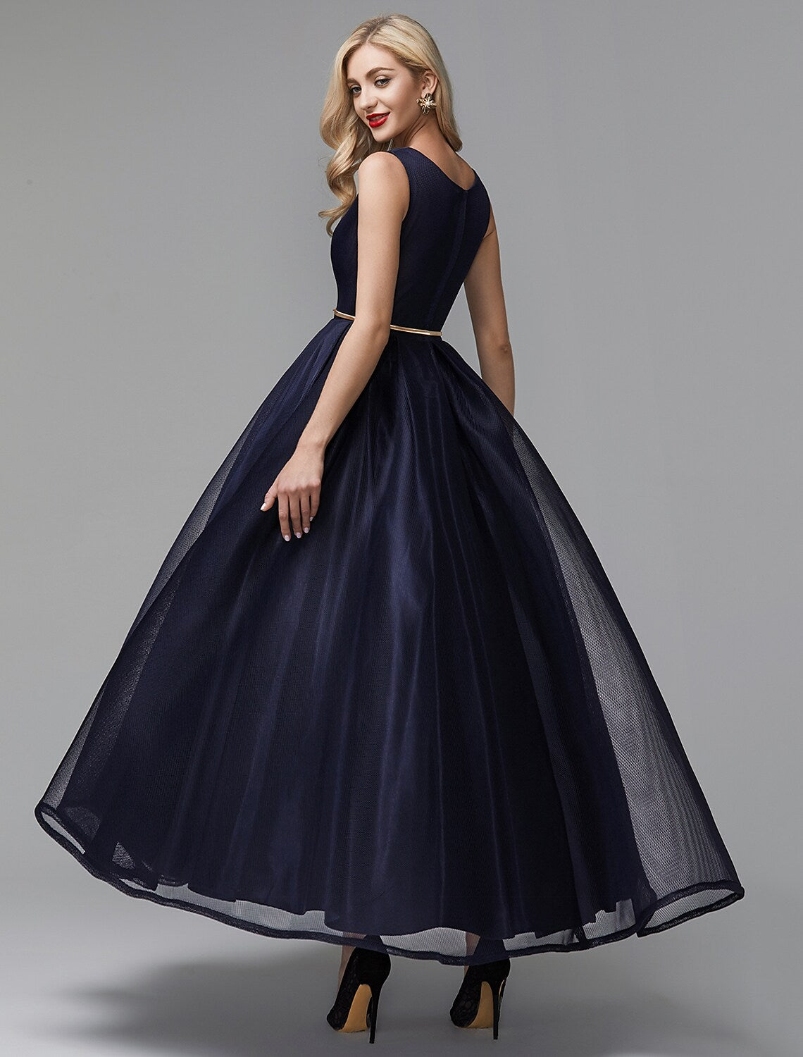 Close-up of the V-neckline and sash detail on the black dress.