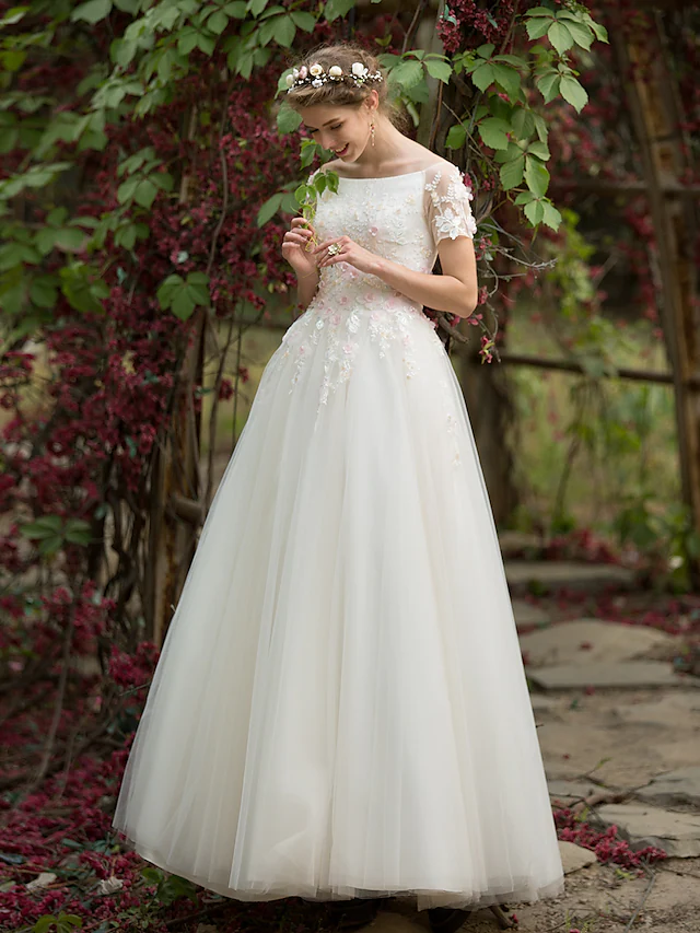 Side view of the floor-length tulle wedding gown with appliques.