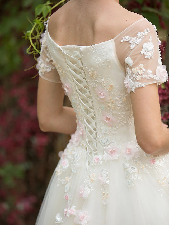 Full view of the A-Line bridal gown with a bateau neckline and short sleeves.