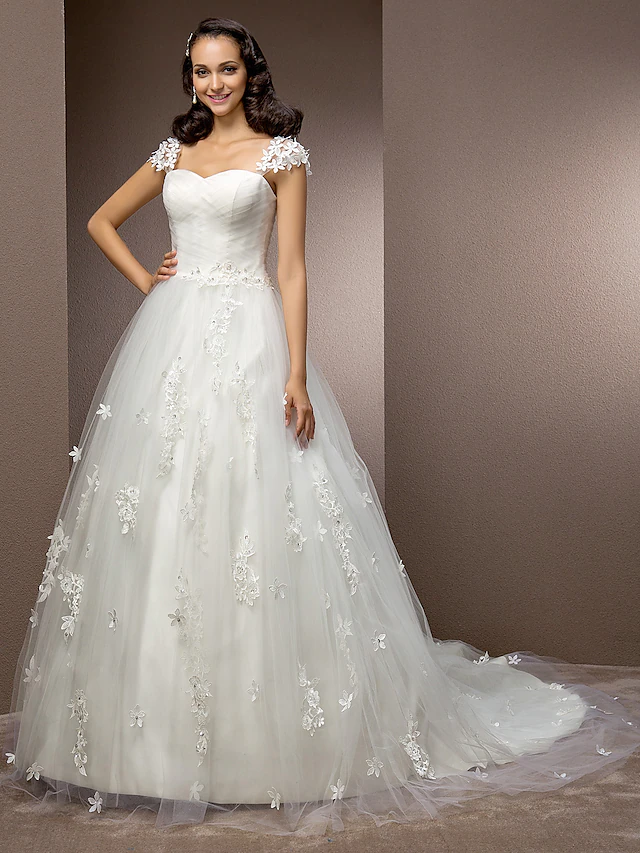 Close-up of ruched tulle and beaded floral details on a wedding dress.