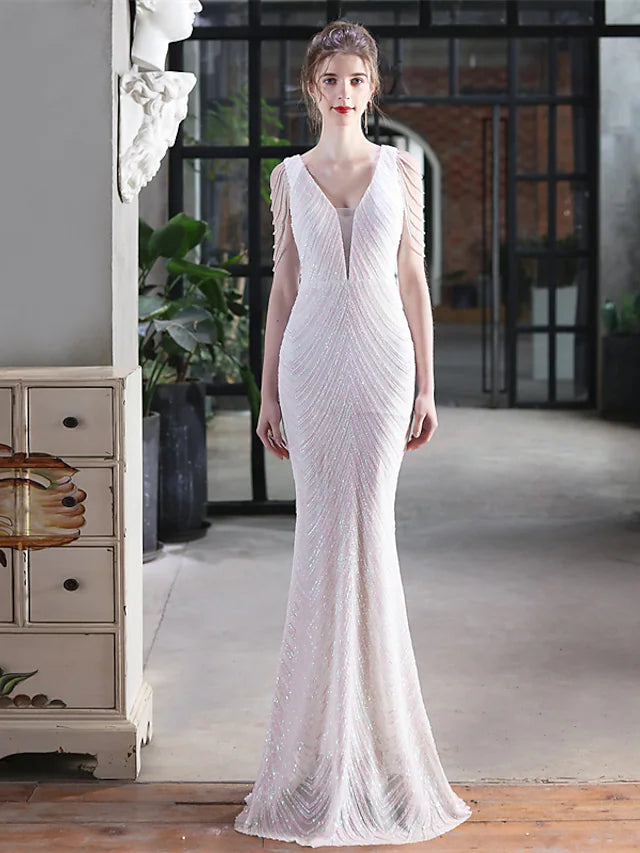 Woman wearing a dazzling sequined mermaid trumpet prom dress with a V-neckline.