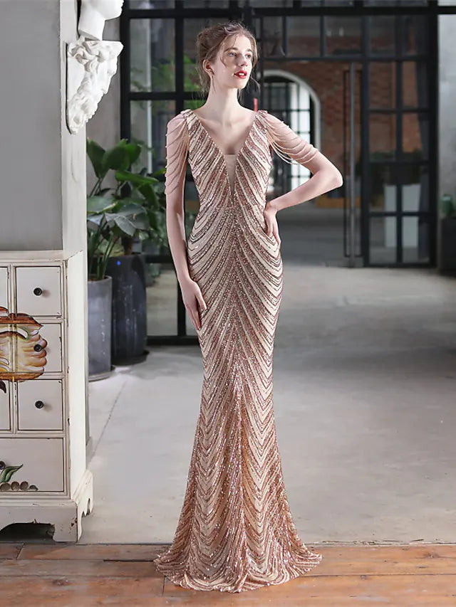 Full view of a woman wearing a shimmering sequined trumpet prom dress.