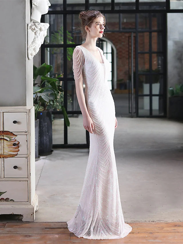 Close-up of the sequined fabric and tassel details on the V-neck mermaid trumpet gown.