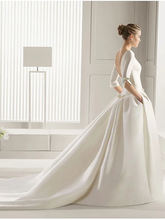 Back view of an A-line wedding dress with a flowing court train.