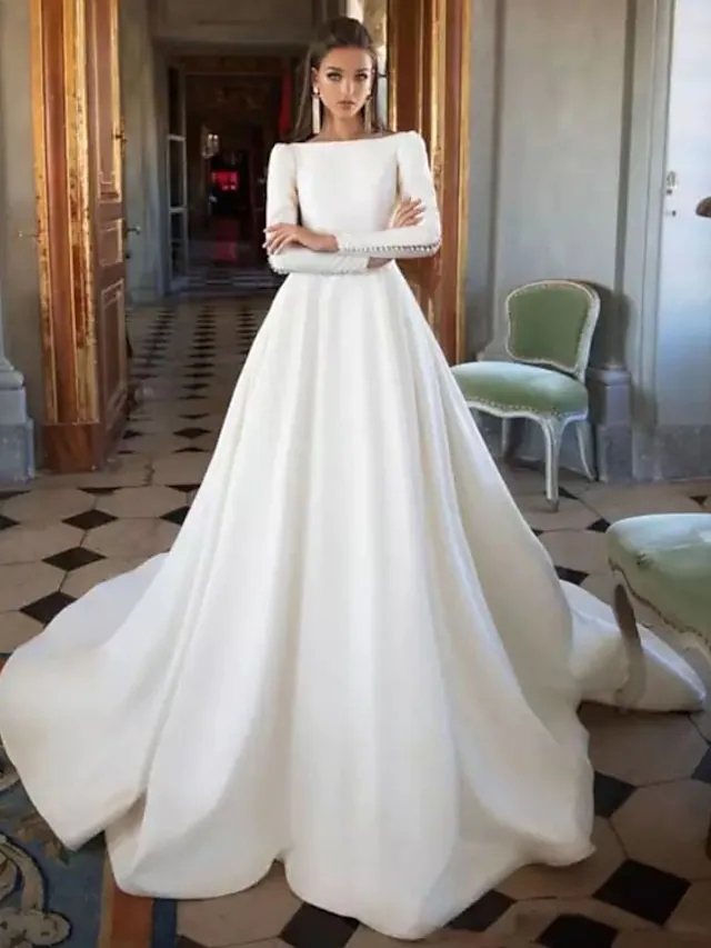 Front view of the elegant A-Line wedding dress with bateau neck and long sleeves.