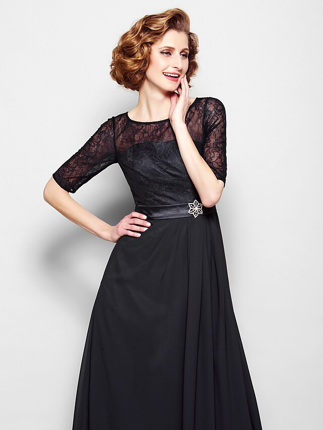 Close-up of chiffon lace fabric and crystal brooch on A-Line dress.