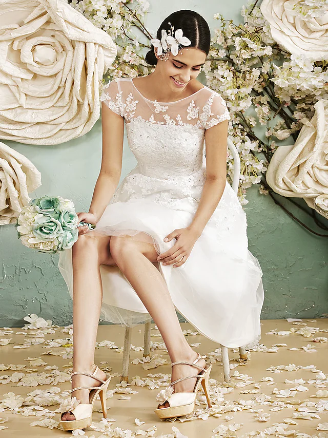 Model posing in the sleeveless floor-length wedding dress.