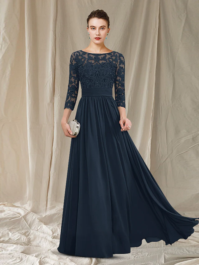 Woman wearing an elegant A-line mother of the bride dress with jewel neck and 3/4 sleeves.