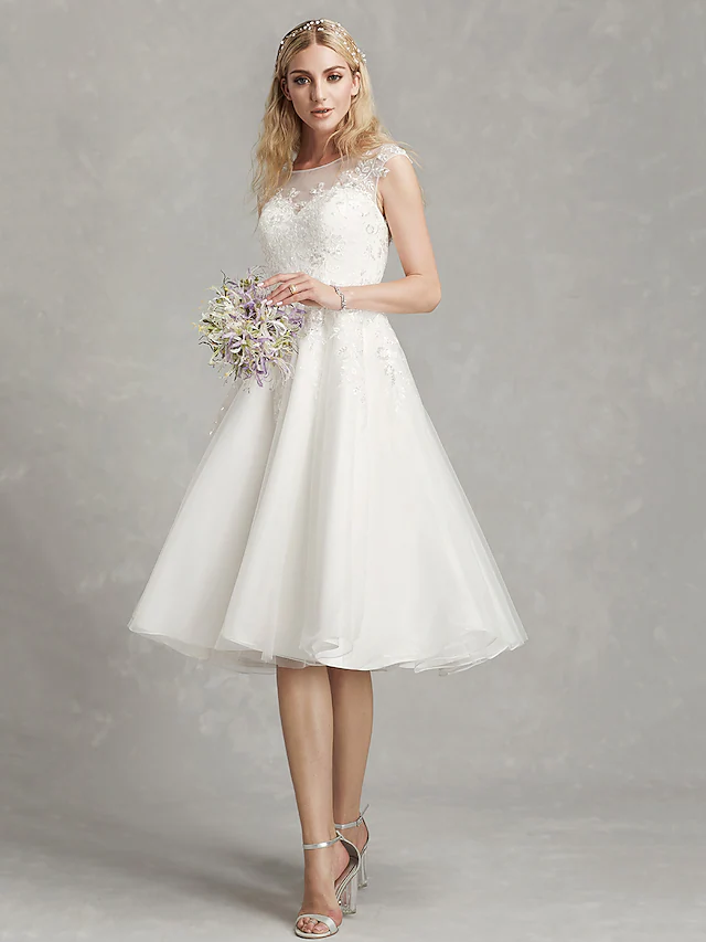 A-Line wedding dress with jewel neck, cap sleeves, and lace appliques.
