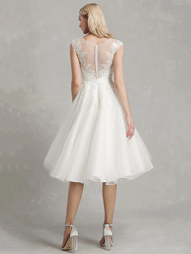 Back view of an A-Line tea length wedding dress with intricate appliques.