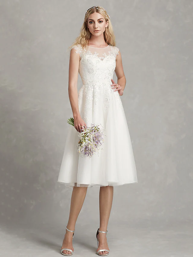Side view of a bride wearing a tea length A-Line wedding dress.