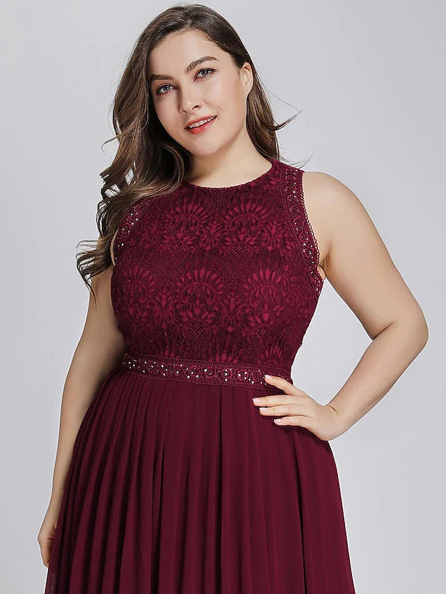 Side view of a woman wearing a sleeveless chiffon gown with crystal details.
