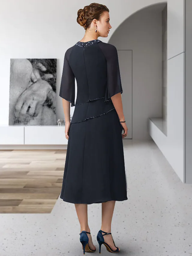 Back view of the tea-length chiffon gown, showing flowing skirt.