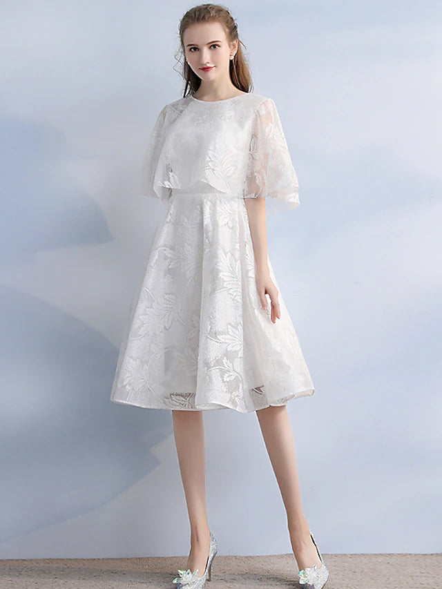 Elegant A-line cocktail dress with jewel neck and half sleeves.